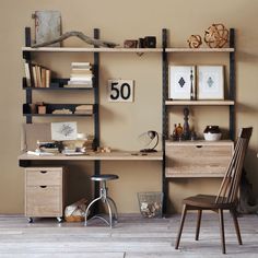 a room with a desk, chair and bookshelf on the wall next to it