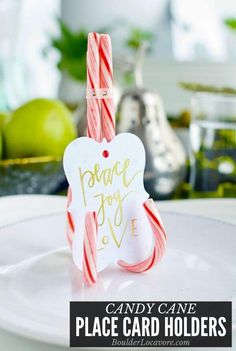 candy cane place card holders on a plate with apples in the background and text overlay that reads, peace joy love