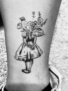 a woman with a flower tattoo on her lower leg is holding a bouquet of flowers