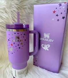 a purple travel mug sitting next to a box