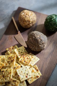 some crackers are on a cutting board next to broccoli and a ball