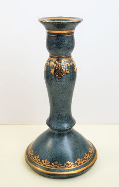 a blue vase sitting on top of a white table next to a black and gold object