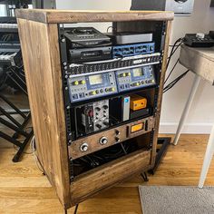 a large wooden case with many electronic equipment in it's centerpiece on top of a hard wood floor