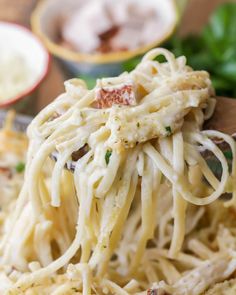 a wooden spoon filled with pasta and sauce