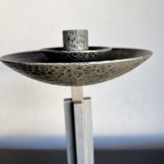 a metal bowl sitting on top of a stand