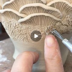 someone is using a brush to paint the base of a mushroom