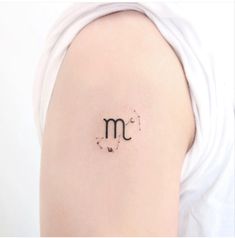 a woman's upper arm with the letter m on her left side and dots in the middle