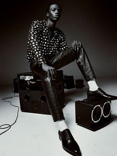 a man sitting on top of a black and white box next to a pair of sunglasses