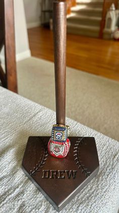 a baseball bat and ring on top of a base in a room with hardwood floors