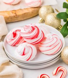 red and white candy canes on plates next to christmas decorations