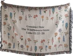 an embroidered pillow with flowers and the words consider how the wildflowers grow like 22 - 28