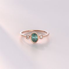 𝐁𝐞𝐳𝐞𝐥 𝐓𝐞𝐚𝐥 𝐒𝐚𝐩𝐩𝐡𝐢𝐫𝐞 𝐑𝐢𝐧𝐠 The Oval Bezel Teal Sapphire Ring is a stunning piece of jewelry crafted in 14k solid gold. This solitaire engagement ring for women features an elegant teal sapphire set in a bezel setting, creating a classic and timeless design. The oval shape of the gemstone adds a touch of sophistication, making it an ideal choice for an anniversary gift. 𝐅𝐞𝐚𝐭𝐮𝐫𝐞𝐬 * Gold KT: 10K, 14K, 18K * Custom Gold Color: Yellow Gold, White Gold, Rose Gold * Top of Ba Elegant Oval Bezel Set Birthstone Ring, Rose Gold Oval Ring For May Birthstone, Oval Bezel Set Jewelry For Anniversary, Oval Rose Gold Birthstone Ring With Bezel Setting, Oval Sapphire Ring May Birthstone Fine Jewelry, Oval Sapphire Ring For May Birthstone, Elegant Emerald Ring With Oval Cabochon Bezel Setting, Rose Gold Emerald Ring With Bezel Setting For Anniversary, Elegant Oval Emerald Ring With Bezel Setting