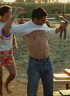 two men are playing frisbee on the beach