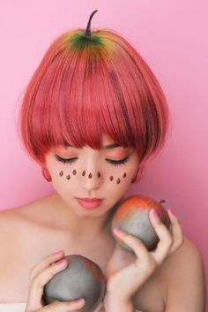 a woman with red hair holding two apples