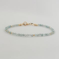 Elevate your style with this dainty aquamarine pale blue crystal bracelet. Adorned with minimalist gemstone beads, this beaded bracelet is a perfect March birthstone accessory. This exquisite piece doubles as a sentimental 19th-anniversary gift for women, making it a thoughtful and stylish Mom gift idea. * Genuine blue aquamarine gemstone beads * March Birthstone * 19th wedding anniversary gift * 2mm - 2.5mm faceted gemstone beads * 14k gold fill or sterling silver  * Chain and findings are nick Delicate Faceted Beaded Bracelets For Everyday, Elegant Aquamarine Faceted Beads Jewelry, Minimalist Crystal Bracelet With Faceted Beads For Everyday, Elegant Aquamarine Jewelry With Faceted Beads, Minimalist Everyday Crystal Bracelet With Faceted Beads, Elegant Adjustable Light Blue Crystal Bracelet, Elegant Light Blue Adjustable Crystal Bracelet, Adjustable Aquamarine Beaded Bracelets, Dainty Faceted Beaded Bracelets For Everyday Wear