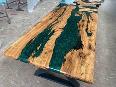 a table made out of wood with green and blue paint on it's surface