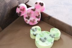 two mickey mouse shaped soaps sitting on top of a brown box next to each other