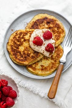 pancakes with whipped cream and raspberries on a plate