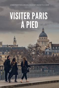 two people walking across a bridge with the words visiter paris a pied