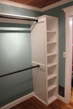 an empty closet with shelves and some rails