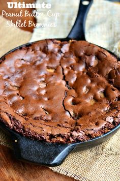 a chocolate cake in a cast iron skillet on top of a wooden cutting board