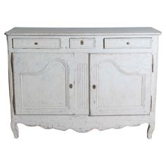 an old white dresser with two doors and drawers