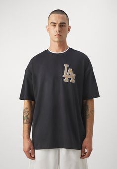 a man wearing a los angeles dodgers t - shirt with the word la on it