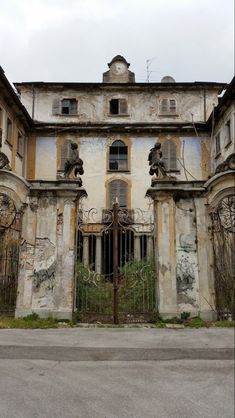 an old building with vines growing out of it's windows and gated entrance