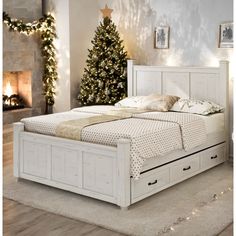 a white bed sitting in a bedroom next to a christmas tree