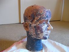 a clay head sitting on top of a piece of cloth next to a door way