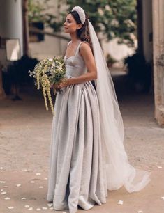 a woman in a wedding dress holding flowers