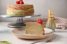 a piece of cake with raspberries on top is sitting on a plate next to a knife and fork