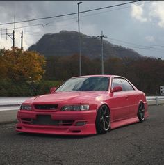 a red car is parked on the side of the road