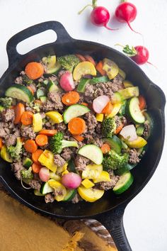 a skillet filled with vegetables and meat