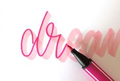 a pink pen sitting on top of a piece of paper next to the word blob