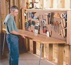 a man standing in front of a workbench filled with tools