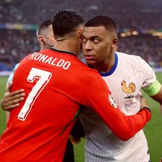 two soccer players embracing each other on the field