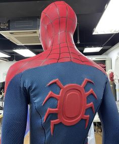 the back of a spider - man costume is shown in an office setting with desks and chairs