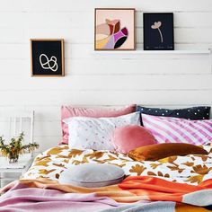 a bed with colorful blankets and pillows on it