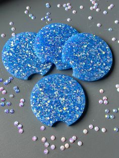 three pieces of blue and white glitter covered cookies