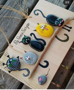 some rocks are sitting on top of a wooden board that says, be happy halloween