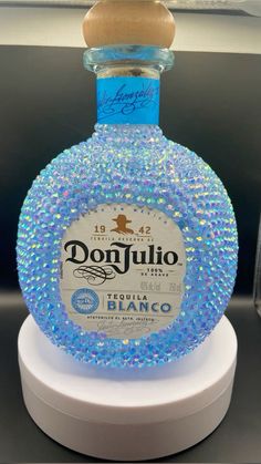 a bottle of donjullo with blue beads on it