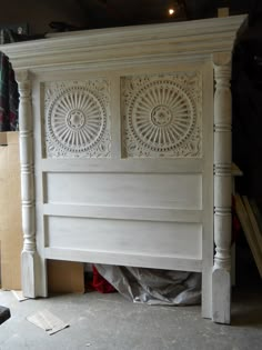 a white bed frame with intricate carvings on the headboard and foot board is being worked on