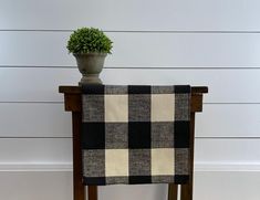 a potted plant sitting on top of a wooden chair next to a white wall