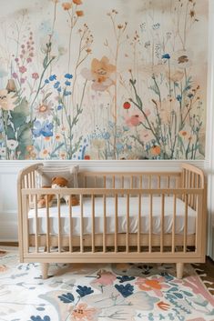 a baby crib in front of a floral wallpaper