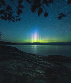 an aurora bore is seen over the water at night