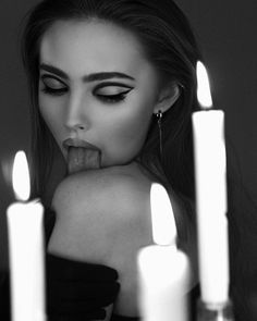 a woman sticking out her tongue surrounded by candles