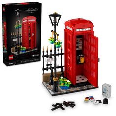 a red phone booth is next to a black fence and street light with legos surrounding it