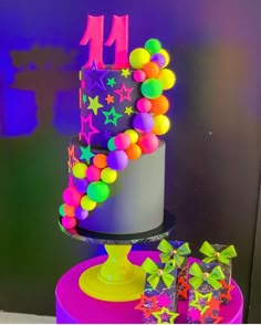 a multi - colored cake with stars and neon colors on the top is surrounded by confetti