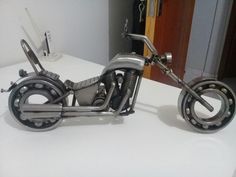 a motorcycle made out of metal parts sitting on top of a white counter next to a door